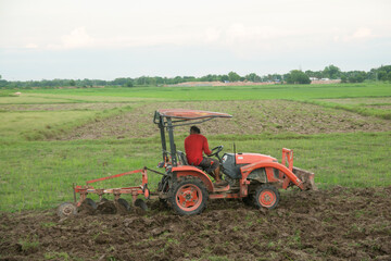 Obraz premium Tractor working plows a field on the farm for planting.