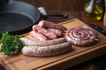 fresh sausages on wooden cutting board