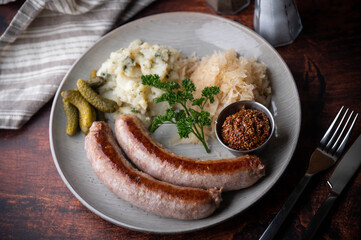 german sausage plate with mustard, potato salad and sauerkraut