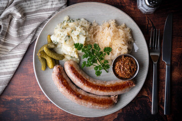 german sausage plate with mustard, potato salad and sauerkraut
