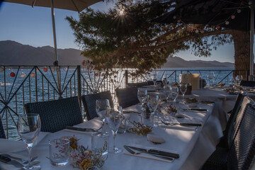 A finely set dining table, outdoors by the sea