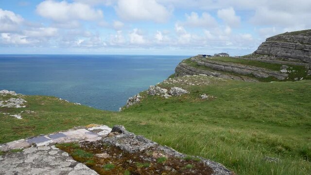 Scenic Great Orme lush Welsh mountain cliff edge rocky grass seascape slow left dolly across coastline