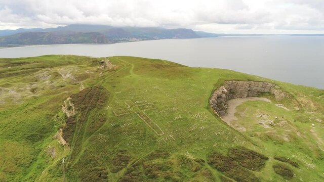 Great Orme Llandudno mountain summit stone hill of names aerial view landmark slow push in tilt down