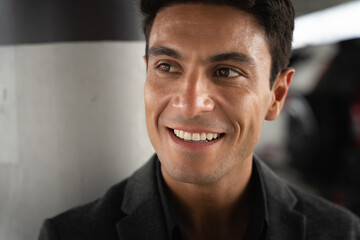 Close up portrait of middle-aged Hispanic businessman looking sideways and little smile with confidence in dark tone atmosphere with copy space, confident and stylish, CEOs style, boss lifestyle.