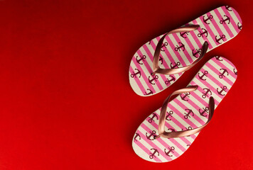 Red flip flops on a bright red background.Copy space.