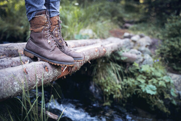 closeup of woman hiking boots on wooden bridge in the woods - Powered by Adobe