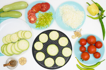 step by step recipe and ingredients for cooking homemade zucchini mini portioned pizza with mozzarella and tomatoes, pepper and garlic. top view on a light background.