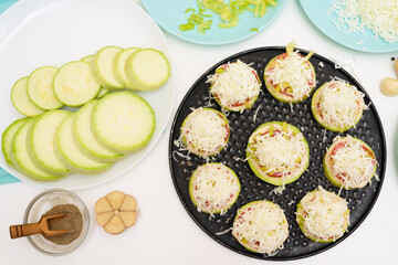 step by step recipe and ingredients for cooking homemade zucchini mini portioned pizza with mozzarella and tomatoes, pepper and garlic. top view on a light background.