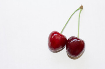 Obraz na płótnie Canvas two cherries on a white background with a copy of the space