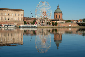 panorama sur monuments et grande roue se reflétant sur l'eau en ville 