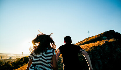 silhouette of a man and a woman in the open air, two young people in nature, silhouette at sunset