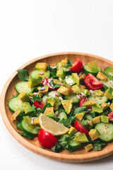 Fresh and healthy summer salad with cucumbers, tomatoes, avocado, arugula, sunflower seeds, lemons and chili flakes. Seasoned with olive oil. White background