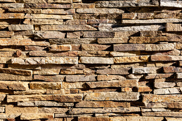 Background of stone wall texture. The surface of the stones is brown