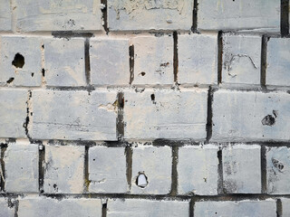 old and dirty brick wall with the remains of paint closeup.