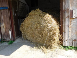 a bale of hay in the doorway to the stable