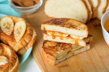 French toast with banana and homemade caramel with cinnamon, Breakfast dessert on a blue plate on a light background