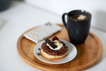A piece of cake on a plate next to a cup of coffee