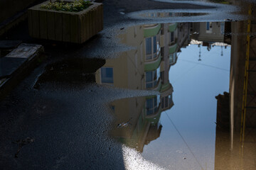 cityscapes in reflections in puddles after rain