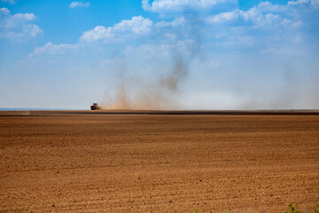 Obraz premium Tractor plowing the fields in spring