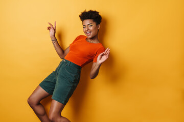 Image of cheerful african american woman singing and dancing on camera