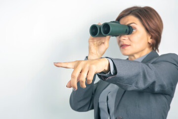 Fototapeta premium Business woman in suit looking through binoculars