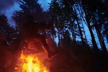 Soldier in Action at Night jumping over fire