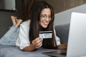 Woman purchasing online while sitting on a couch