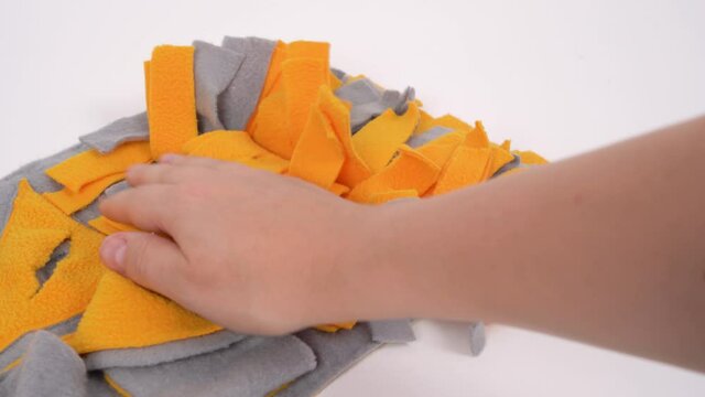 Owner checks and cleans a soft washable textile training snuffle mat for dogs nose work from wool and small debris before using, and hides snacks