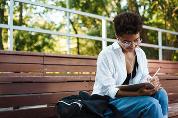 Obraz premium Concentrated african woman reading book