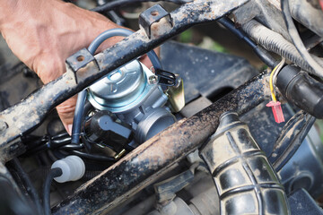 Replacing the scooter's carburetor with a new one.