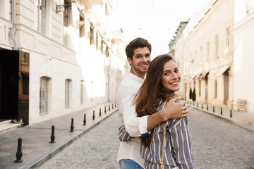 Happy beautiful couple walking in a city street © Drobot Dean