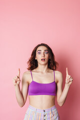 Image of redhead shocked woman in bra pointing fingers upward