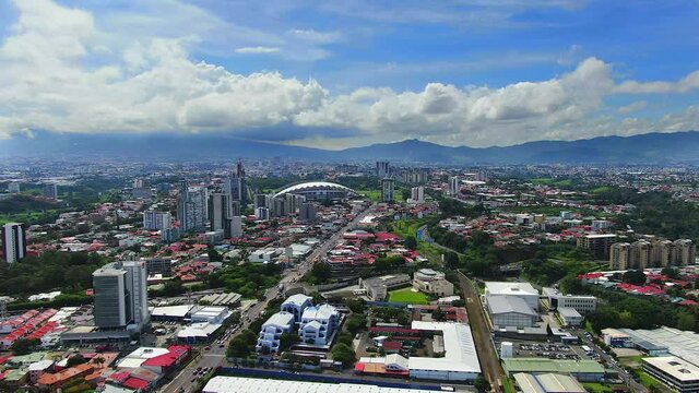 Cinematic aerial footage of the city of San Jose, with the national stadium, La Sabana Park and skyscrapers in Costa Rica