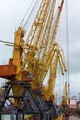 Fototapeta premium Odessa, Ukraine - October 13, 2016: Container cranes in cargo port terminal, cargo cranes without job in an empty harbor port. A crisis. Defaulted paralyzed entire economy