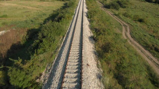 Fast aerial pan up of a long railway track in Serbia near Novi Becej.