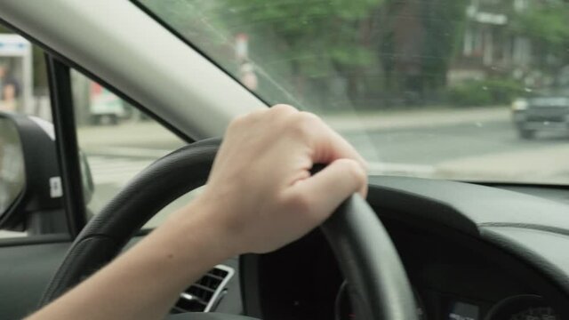 Close up of woman's hands on the wheel of a car driving