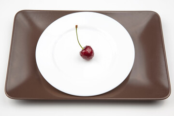 juicy cherry berries lie on a white plate. healthy food for breakfast. fruits of vegetation. fruit dessert