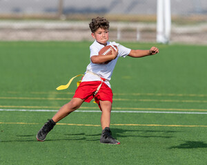 Cute athletic little boy playing excitedly in a flag football game © Joe