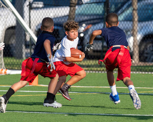 Cute athletic little boy playing excitedly in a flag football game
