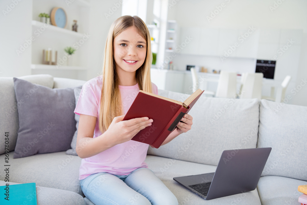 Poster photo of positive girl kid study remote sit divan read diary fiction story book wear t-shirt denim j