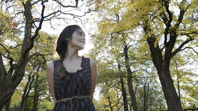 Young beautiful Asian woman with autumn trees in the forest