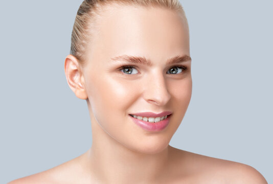 Portrait of a beautiful smiling blonde woman with naked shoulders, with blue eyes, plump lips,  clean skin and fresh make-up. Aesthetic cosmetology, hair treatment and makeup concept.