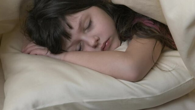 Child sleep on the pillow. Adorable little girl sleeping peacefully on a pillow in bed.
