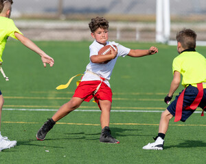Cute athletic little boy playing excitedly in a flag football game - Powered by Adobe