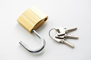 golden colored padlock with keys on a white background. private security and safety concept