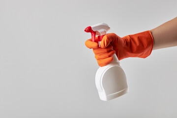 cleaner wear orange rubber washing gloves and holding white blank cleaning spray. studio shot. copy...