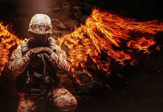 Soldier in uniform kneeling with fire wings on his back.