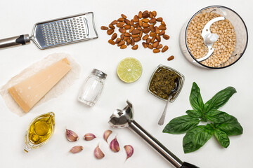 Fototapeta na wymiar Pesto sauce. Cutter with pine nut, whisk, grater, pesto bowl, basil leaves, parmesan, garlic, lemon.