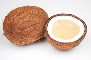 coconut halves with coconut, milk and pulp on a white background
