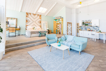 Fashionable spacious apartment with a stylish design in green, grey and white pastel colors with big window and decorative walls. bedroom and kitchen space